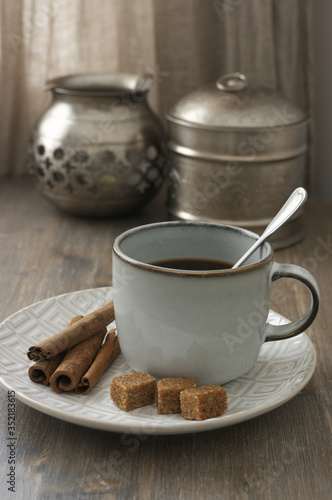 Coffee with cinnamon and silver utensils