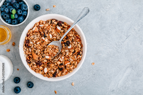 Granola cereals with fresh blueberries, almonds, milk and honey for breakfast.