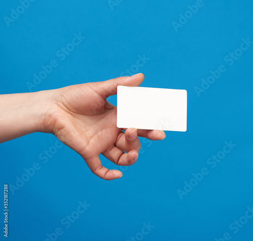 female hand holds a rectangular white paper blank business card