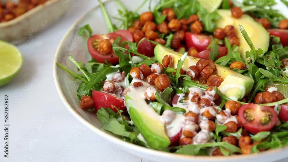 Roasted chickpea salad with avocado and tomatoes in white bowl. Healthy vegan food concept. Roasted chickpea salad with avocado and tomatoes in white bowl. Healthy vegan food concept.