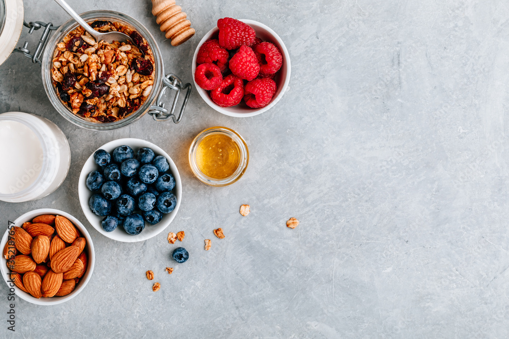 Granola cereals with fresh berries, almonds, milk and honey for breakfast. Granola cereals with fresh berries, almonds, milk and honey for breakfast.