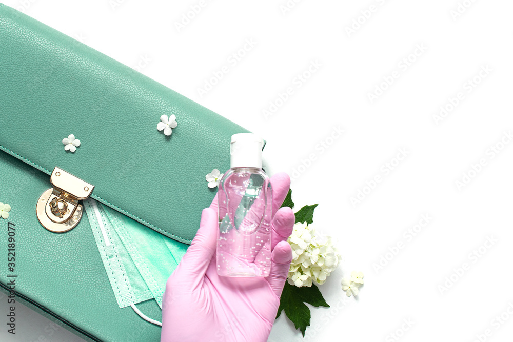 green leather women bag with a medical mask, a sanitizer and gloves. Concept spring-summer 2020 exit from the coronavirus pandemic. protective equipment after isolation. green leather women bag with a medical mask, a sanitizer and gloves. Concept spring-summer 2020 exit from the coronavirus pandemic. protective equipment after isolation.