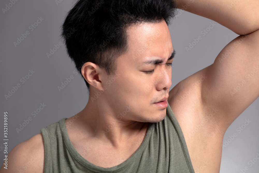 young man sniffing his armpit young man sniffing his armpit
