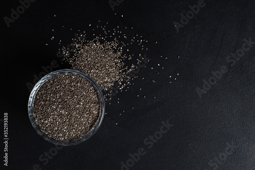 Chia seeds in a cup beautifully laid out on a black background. Top view. copy space. Vegetarian food.