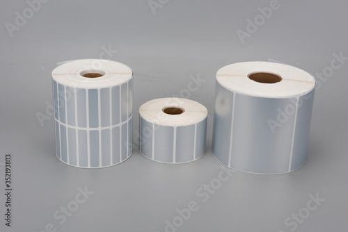 A few rolls of silver thermal print label paper
