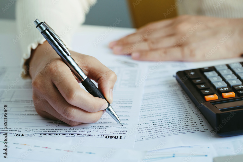 Women filling US tax form. tax form us business income office hand fill concept.work from home Women filling US tax form. tax form us business income office hand fill concept.work from home