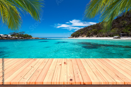 Wooden floor or plank on sand beach. For product display.Calm Sea and Blue Sky Background.tropical in summer.
