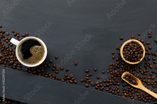 cup of coffee on black wooden floor background. top view. space for text