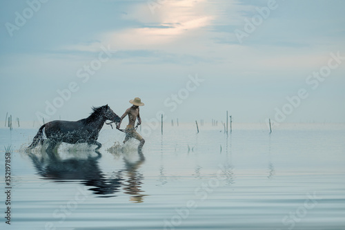 young running with horse in the sea