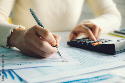  Closeup woman filling form of Individual Income Tax Return, photo