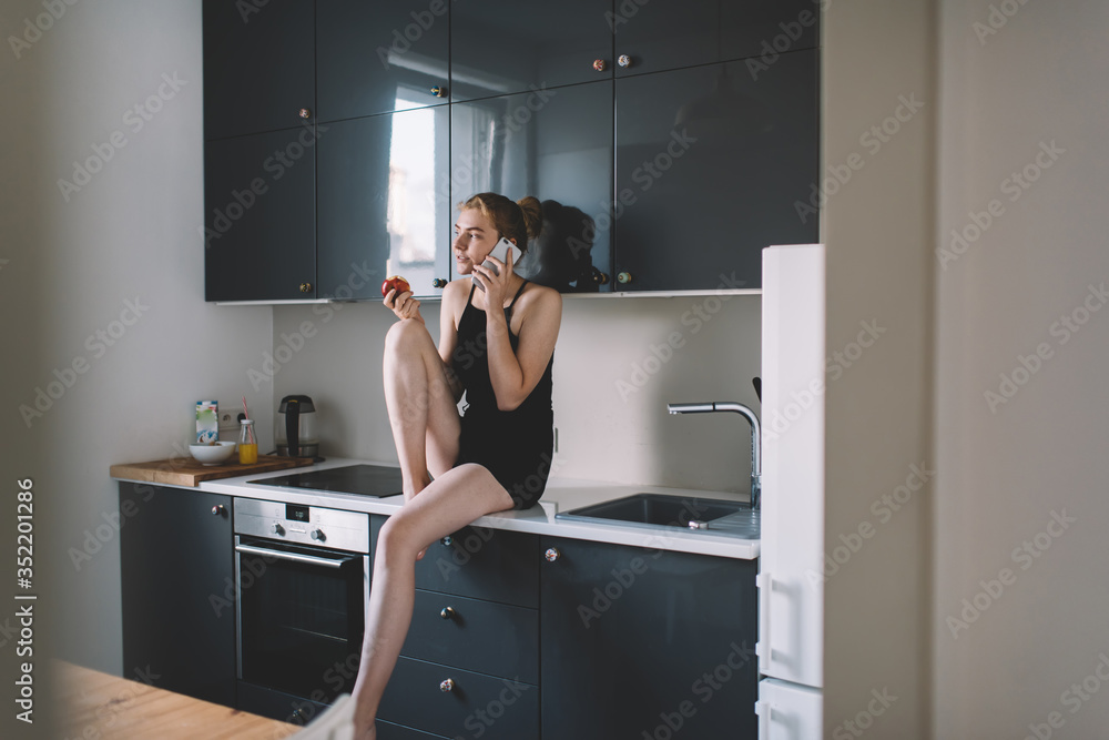 Positive woman talking on phone at kitchen Positive woman talking on phone at kitchen