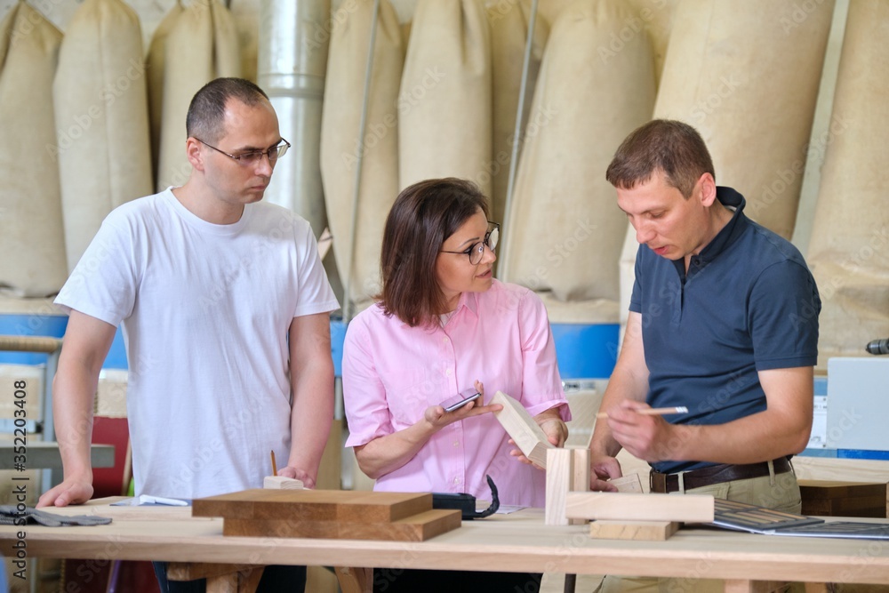 Fototapeta premium Industrial woodworking workshop, team of people discussing carpentry process