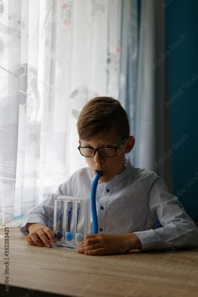 Young boy deep breathing exercise with triballs incentive spirometer