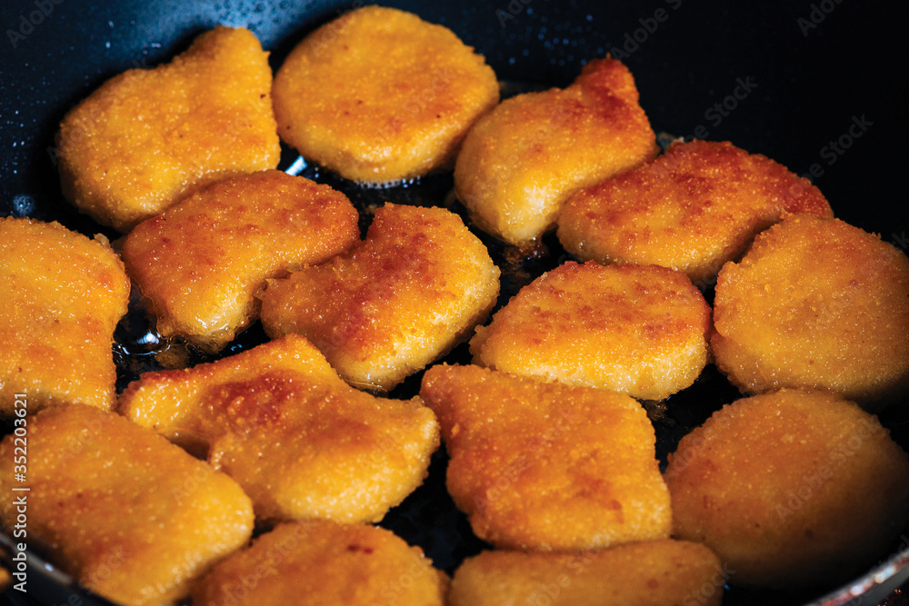 Chicken nuggets fried in a pan with butter Chicken nuggets fried in a pan with butter