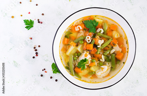 Minestrone, italian vegetable soup with pasta on light table. Top view, flat lay, copy space