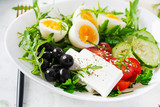 Breakfast. Greek salad and boiled eggs.  Fresh vegetable salad with tomato,  cucumbers, olives, arugula and feta cheese. Trend food.