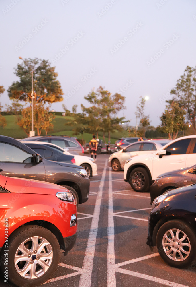 Image of cars parking in the opposite side in outdoor parking with natural background in twilight evening. Vertical view.