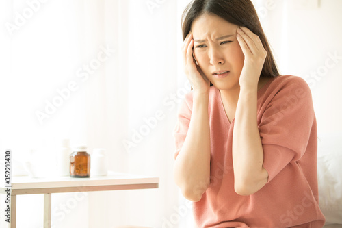 Women feel headaches and fever, sitting on the bed, sick. Health Care Concept, Virus