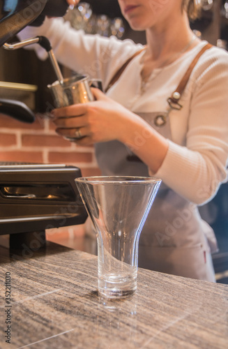 Wallpaper Mural Making Latte - a large transparent glass for Latte. In the background is a girl at a coffee machine. Torontodigital.ca