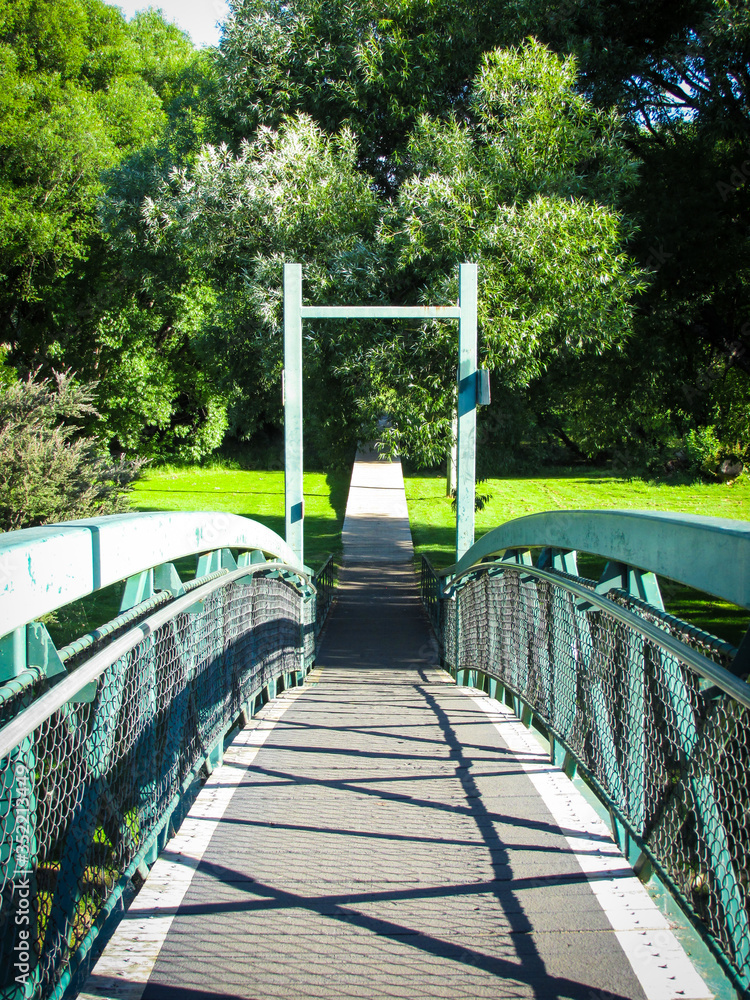 Metal pedestrian bridge over Meander River. The bridge is located near Deloraine Apex Caravan Park. On the other side of the bridge is Deloraine Rotary Park Reserve. Deloraine is a tourist destination