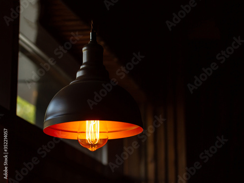 Vintage lamp in a darkened room, yellow light, copy space on the right photo