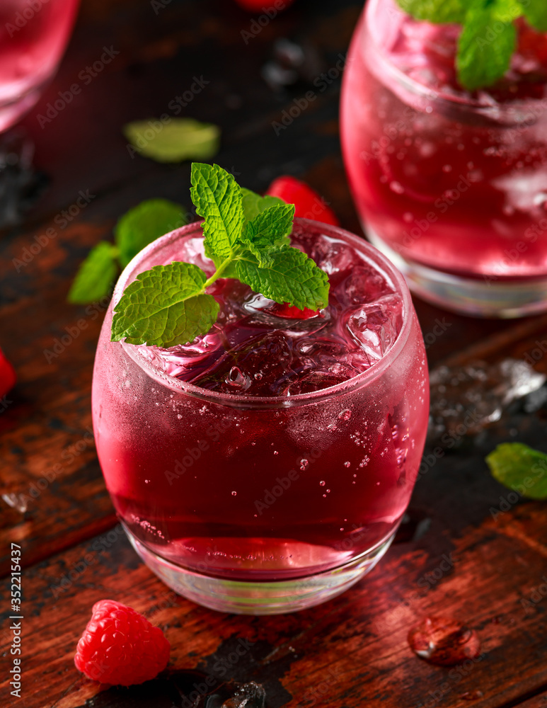 Refreshing raspberry cocktail with ice and mint on wooden table Refreshing raspberry cocktail with ice and mint on wooden table