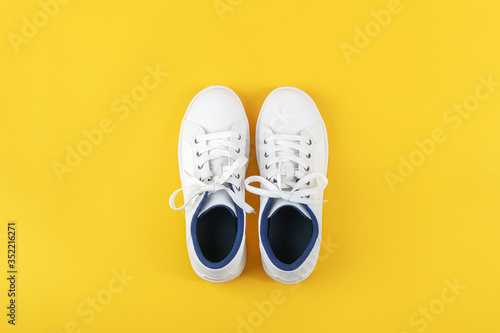 White sports shoes, sneakers with shoelaces on a yellow background. Sport lifestyle concept Top view Flat lay Copy space