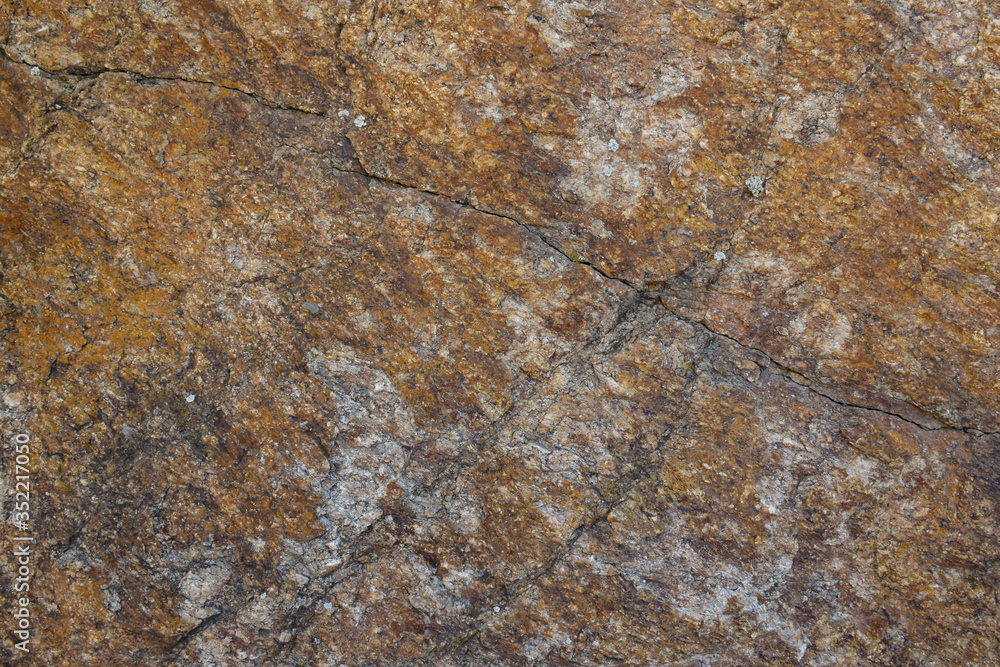 Texture of natural stone. A grey granite stone with cracks and rusty stains. Texture of natural stone. A grey granite stone with cracks and rusty stains.