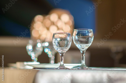 Empty wine glasses on table in restaurant against vintage blurred background