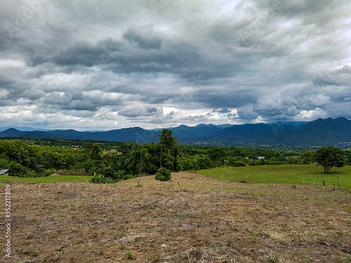 Dark grey clouds sky big carpet big background mountains hills green trees rain forest view pai north thailand photo