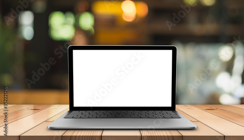 Laptop with blank screen on wooden table