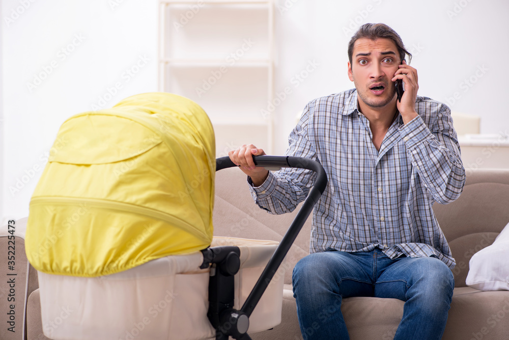 Young father looking after newborn baby at home