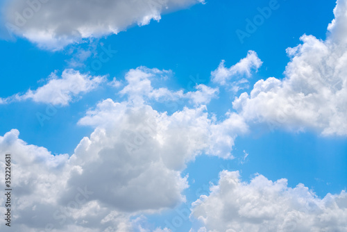 The blue summer sky with white fluffy clouds. Photo from window on the airplane.