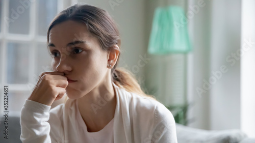 Close up of unhappy distressed young Caucasian woman look in distance thinking pondering having life problems, upset frustrated female lost in thoughts, suffer from troubles, depression concept