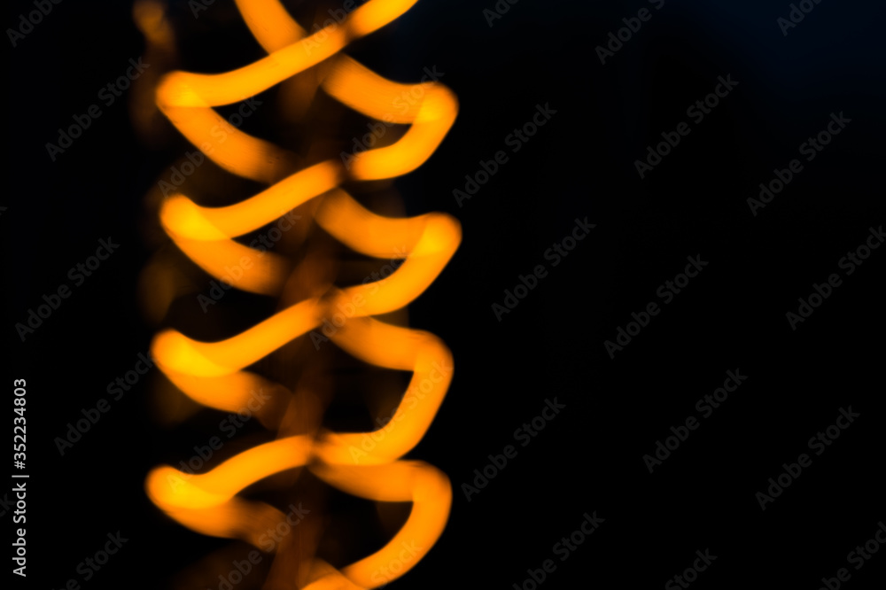 Blurred shot of shining edison light bulb on black background Blurred shot of shining edison light bulb on black background