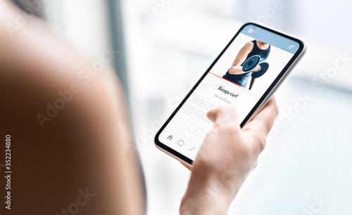 Gym training app in phone. Online personal trainer or video tutorial mockup in smartphone. Home workout with fitness class or digital sport coach. Exercise instruction. Getting fit. Mobile technology.