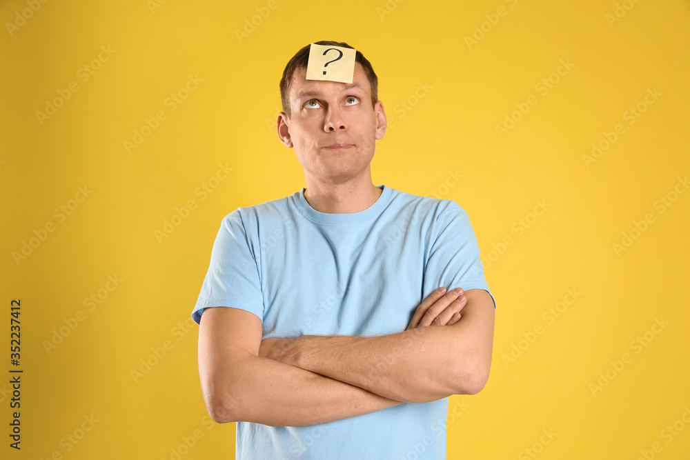 Emotional man with question mark on yellow background Emotional man with question mark on yellow background