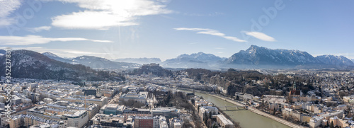 Panoramic aerial drone view of Salzburg snowy old town of Hohensalzburg fortress Unesberg mountain in winter morning