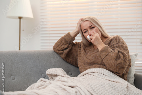 Mature woman suffering from cold at home. Dangerous virus