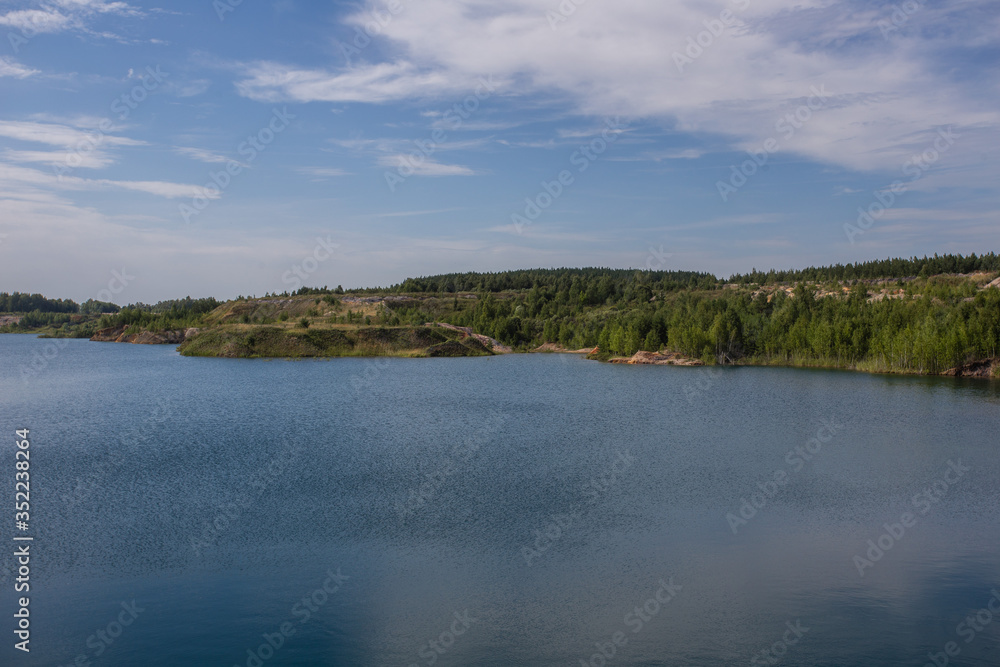 Flooded kaolin clay open pit quarry with blue water lake Flooded kaolin clay open pit quarry with blue water lake