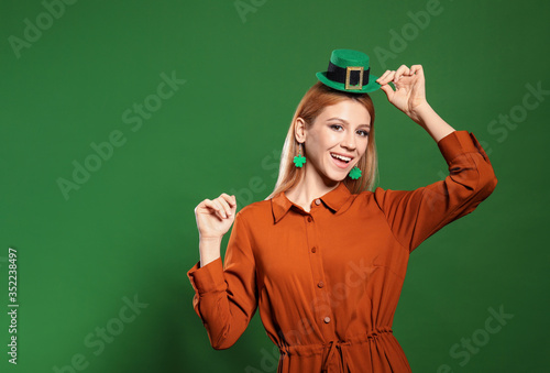 Young woman in leprechaun hat on green background, space for text. St. Patrick's Day celebration