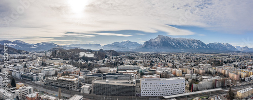 Panoramic aerial view of Salzburg outskirts railway station with view of snowy untersberg and old town