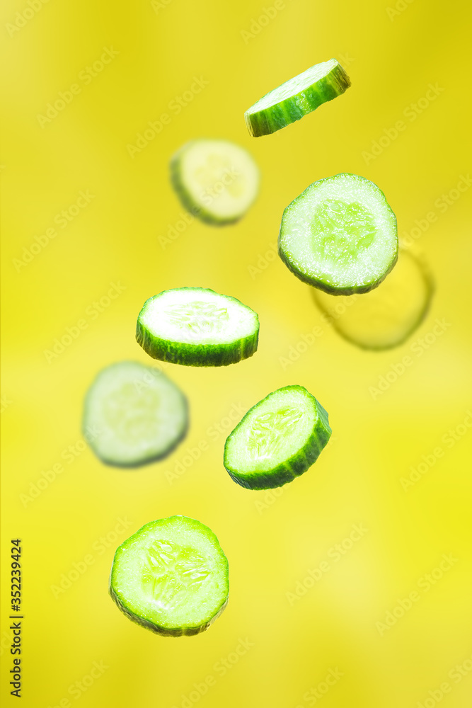 Abstract yellow background with fresh chopped cucumbers