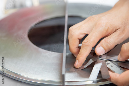 Instrument technician measuring flatness of orifice plate by using filler gauge for inspect the condition of measurement element.