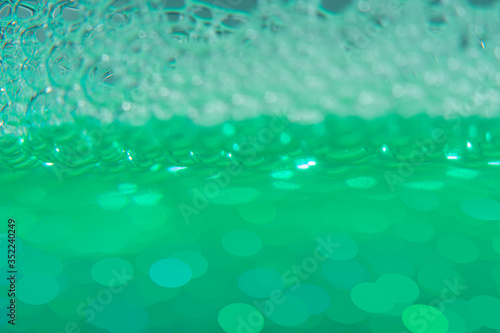 Blurred abstract light green background with bubbles. The concept is summer, soft drinks, freshness. For the backing of a site or mobile application.