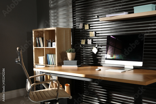 Comfortable workplace with office chair and computer on wooden table photo