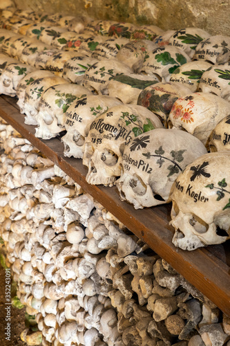 View of hundreds of painted skulls and bones inside the famous charnel house at the mountain village Hallstatt in the Salzkammergut region, Austria photo