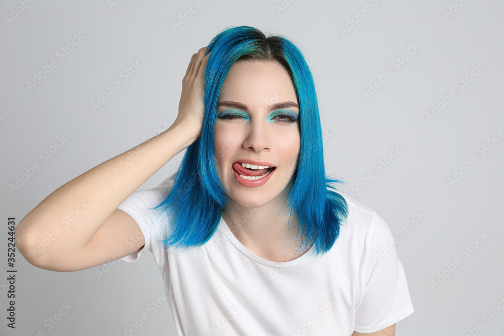 Young woman with bright dyed hair on light grey background Young woman with bright dyed hair on light grey background