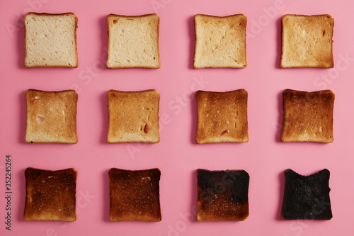 Isolated overhead shot of bread toasts in different stages of roasting against rosy background. Last slice is completely burnt. Snack for breakfast. From unroasted to charred. Food photography