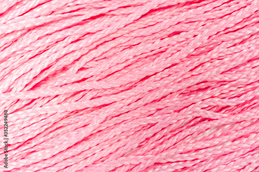 Fototapeta premium Beauty pastel background. Beautiful pink braids backdrop. Space for text and design. Trendy shades of the texture. Close up